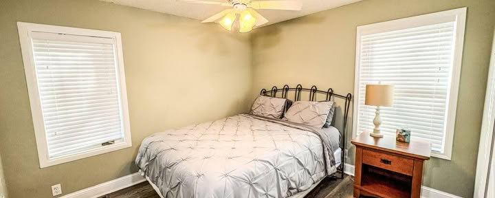 Een queensize bed met gedeelde badkamer