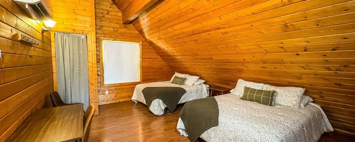 Één queensize loftbed in een gedeelde cabine-loft met twee queensize bedden en gedeelde badkamers